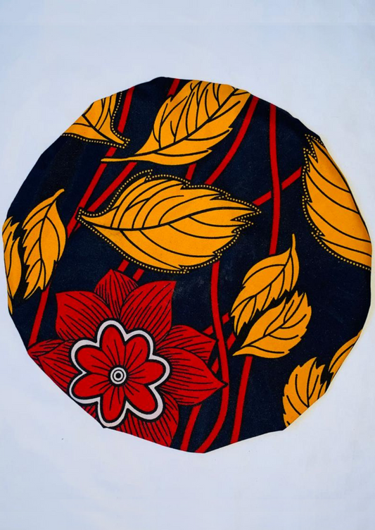 With a Navy base, this African print bonnet is brought to life by orangey yellow leaves and a deep red flower to create an autumnal satin bonnet.