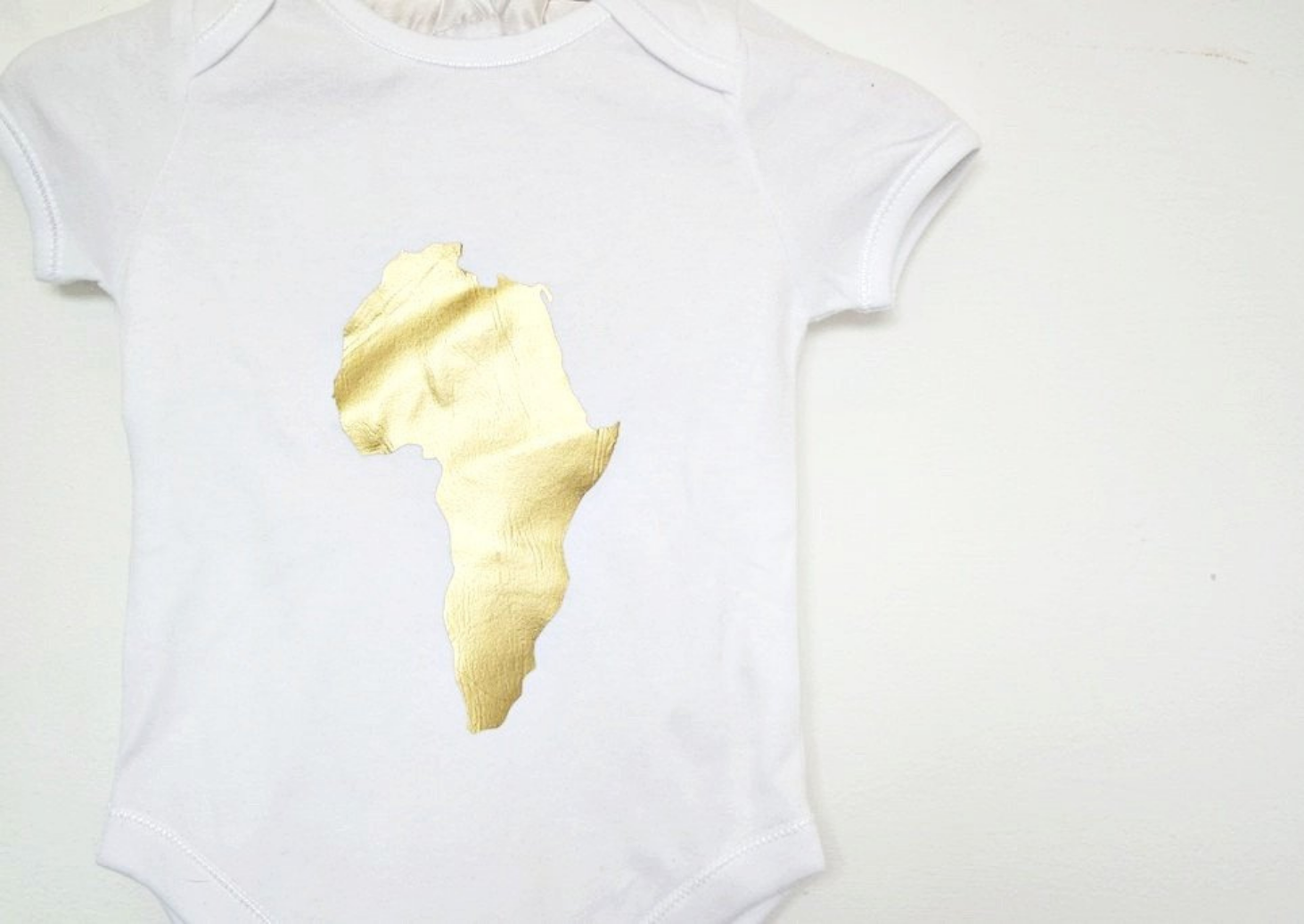 Baby bodysuit: This baby romper is a white short sleeve playsuit with gold map of Africa on the centre of the chest.