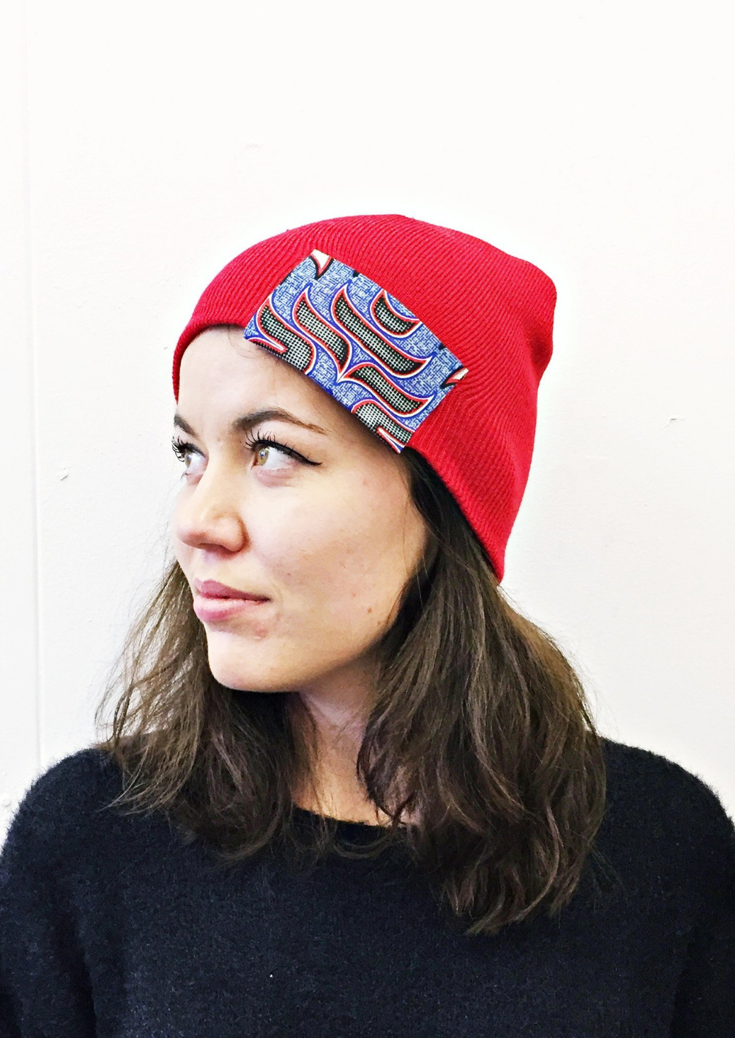 Part of our collection of ladies beanie hats, this red beanie hat with blue African print patch is a unique addition to your African accessories.